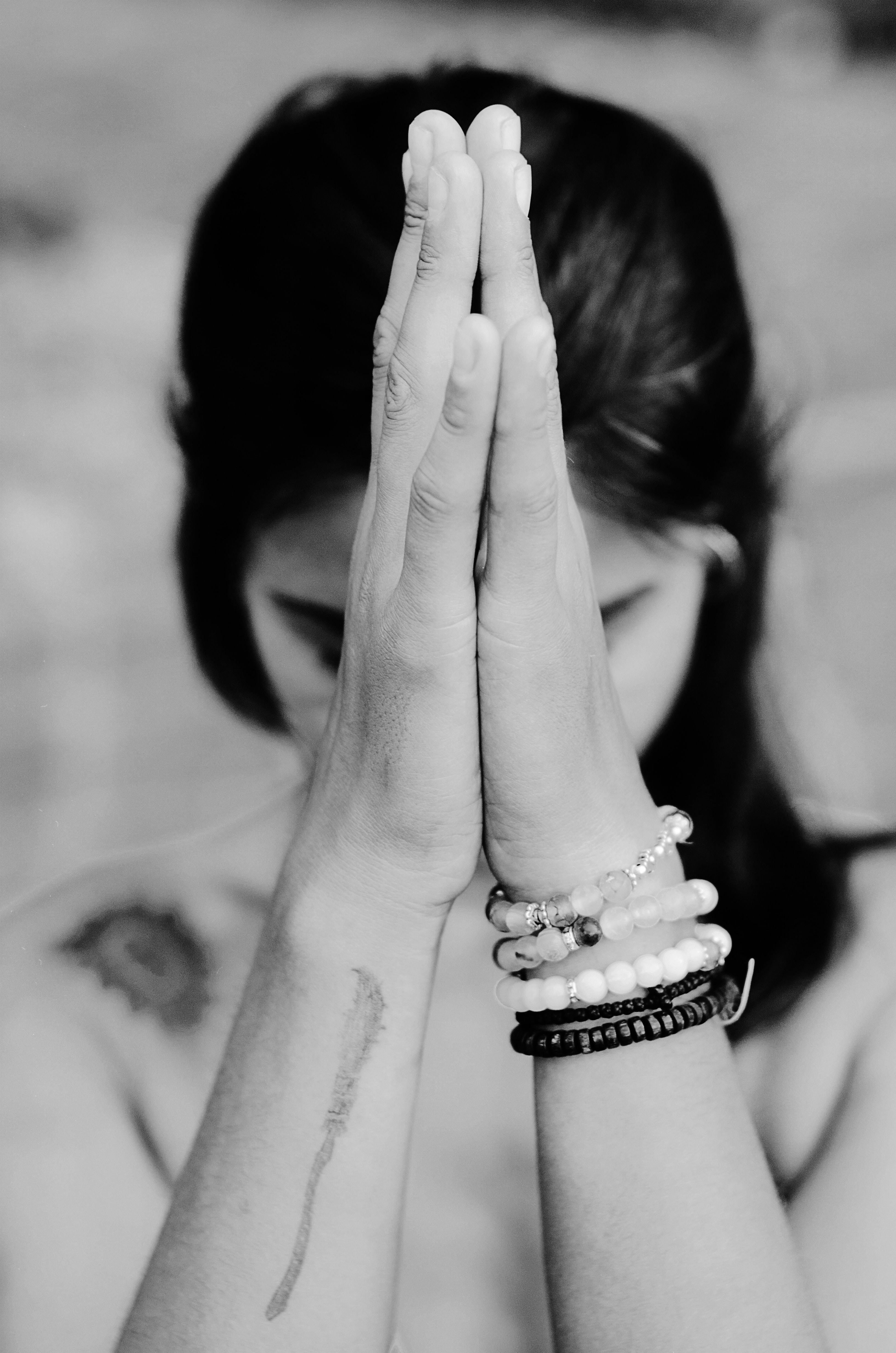 A woman with folded prayer hands. The quiet return to herself.